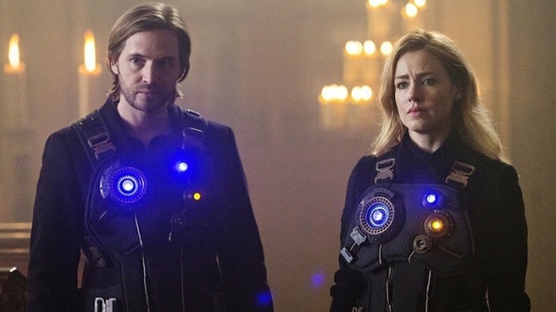Aaron Stanford as James Cole and Amanda Schull as Cassandra Railly wearing vests with lights on them in 12 Monkeys
