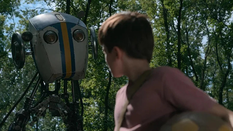 Duncan Joiner as young Cole facing away from camera and toward friendly-looking robot with big eyes in Tales from the Loop