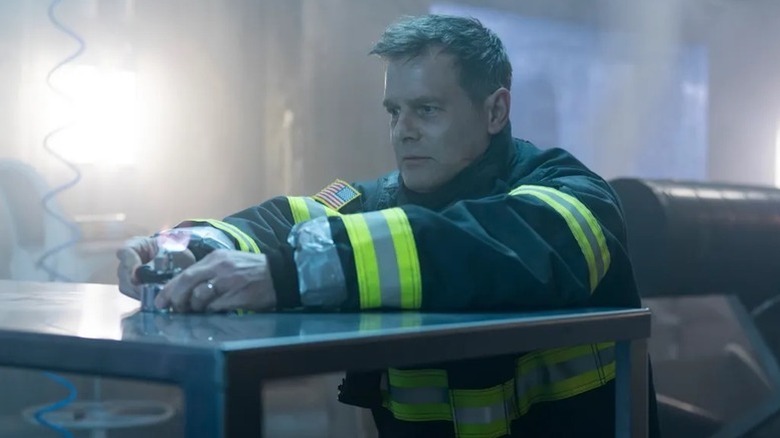 Bobby Nash (Peter Krause) holds a device in a lab in 9-1-1