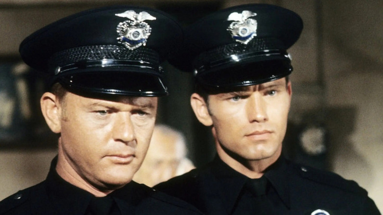Pete Malloy (Martin Milner) and Jim Reed (Kent McCord) look intently while wearing police uniforms in Adam-12