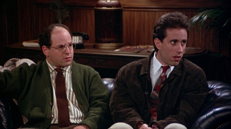 George Costanza (Jason Alexander) and Jerry Seinfeld sit together in an ornate office in Seinfeld