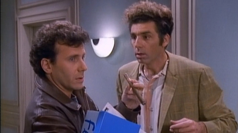 Paul Buchman (Paul Reiser) talks to Cosmo Kramer (Michael Richards) in a hallway in Mad About You