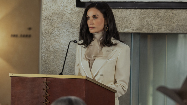 Demi Moore as Cami Miller stands at a podium in Landman