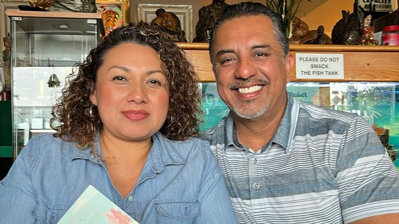 Izzy Battres and his wife smiling in a restaurant