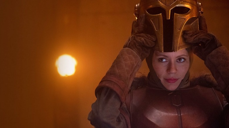Emily Swallow, taking off her mask as the Armorer from The Mandalorian