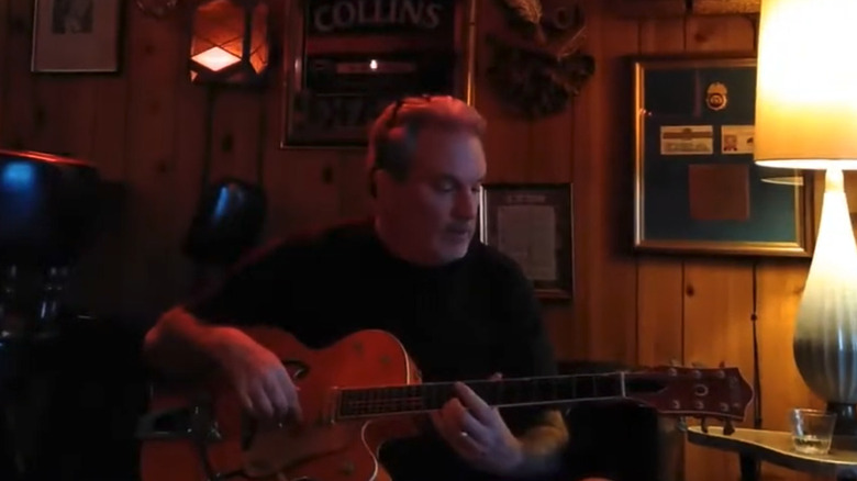 John Troy Donovan plays guitar for a video on his YouTube channel