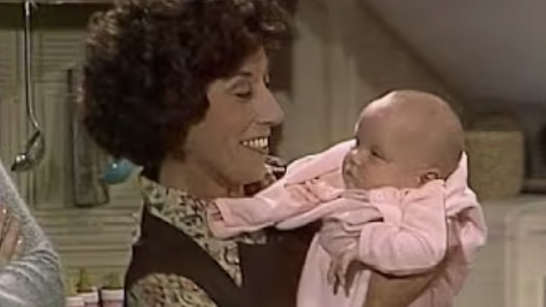 Mrs. Horshack-O'Hara holding a baby and smiling