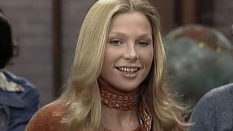 Melonie Haller as Angie Grabowski smiling and wearing a scarf in Welcome Back Kotter