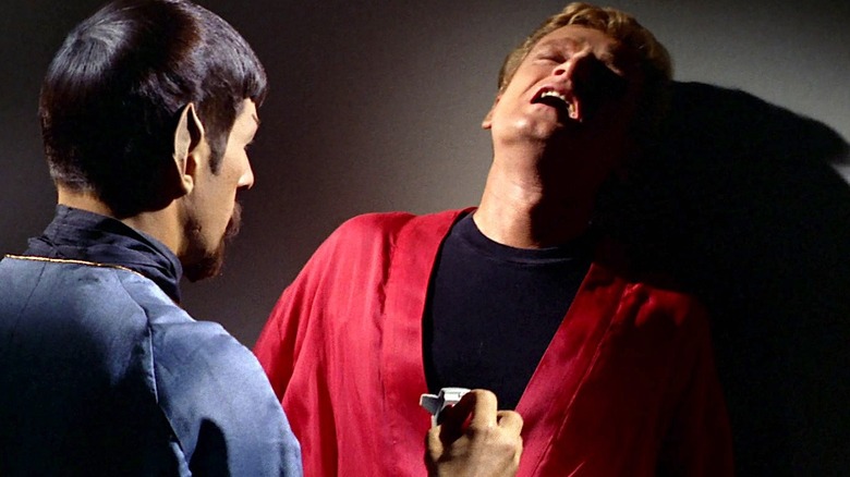 Spock holding a small Agonizer device to an agonized man's chest in Star Trek