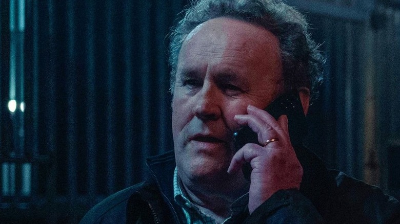 Kieran (Colm Meaney) speaks on a cell phone in Safe Harbor (2025)
