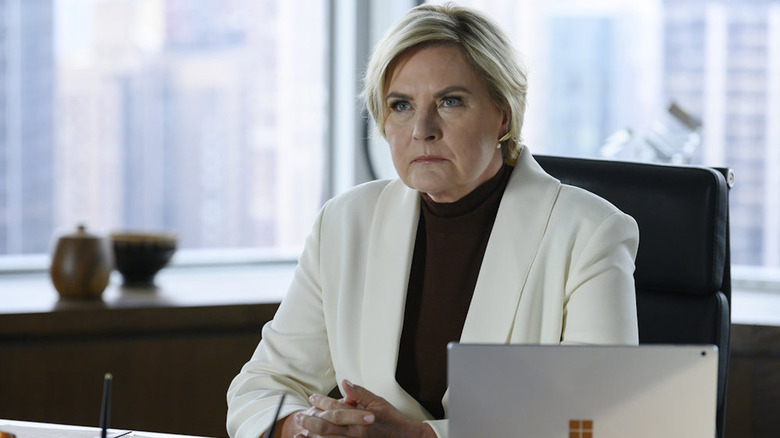 Faye Richardson (Denise Crosby) sits sternly at her desk on Suits