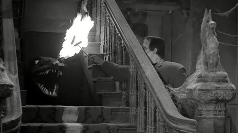 Spot breathes fire from under the stairs in "The Munsters" (1964)