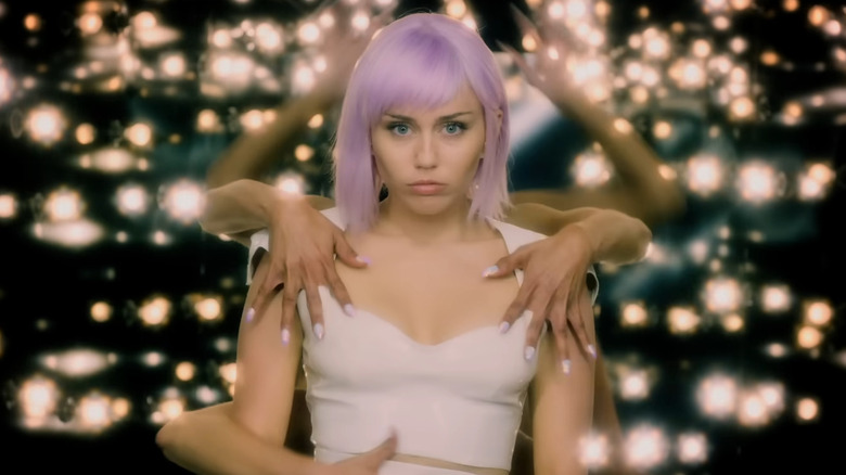 Miley Cyrus as Ashley, performing with hands surrounding her in Black Mirror