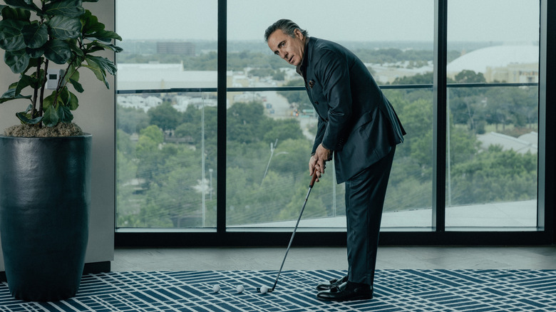 Andy Garcia as Gallino plays golf in his office in Landman