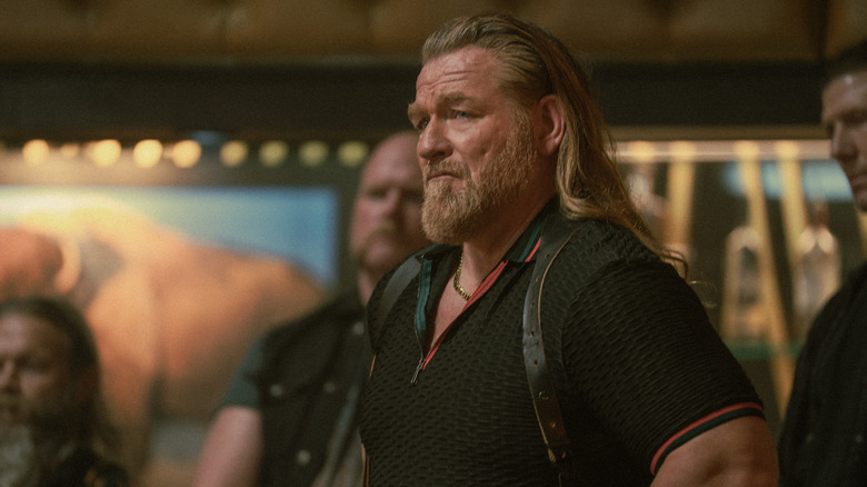 Bigfoot in black polo and shoulder holster standing in bar