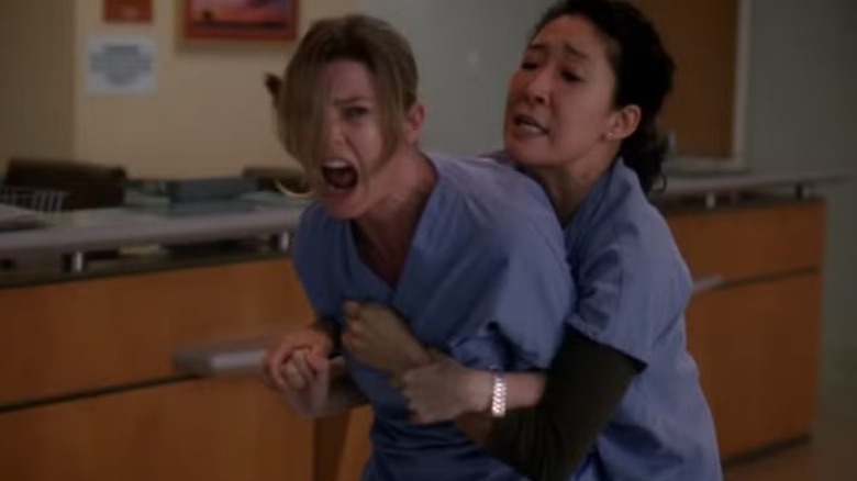 Meredith Grey being held by Cristina Yang while she screams