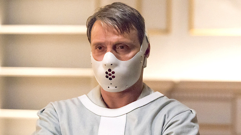 Hannibal Lecter wears a white face mask while wrapped in a straight jacket in "Hannibal" (2013-2015)