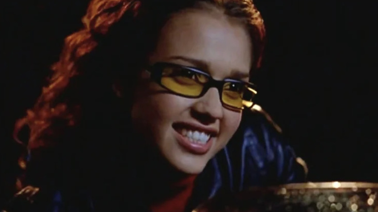 Jessica Alba as Max Guevara with shoulder-length dark hair and yellow-tinted glasses.