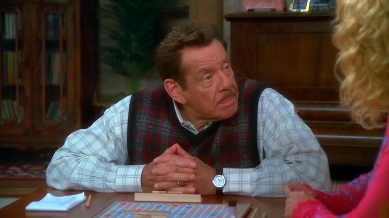 Arthur sitting at table with hands crossed