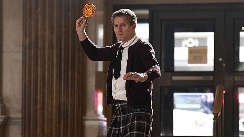 Liam Neeson as Frank Drebin Jr. preparing to throw a lollipop in The Naked Gun