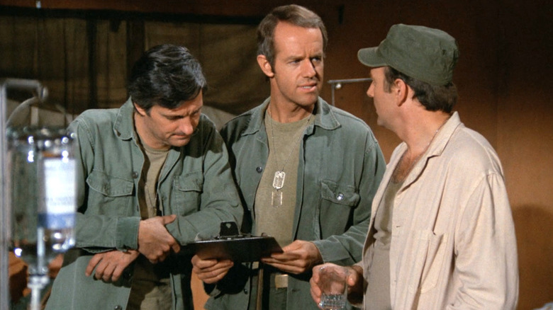 Hawkeye, B.J. Hunnicutt, and Frank talking about patients in M*A*S*H