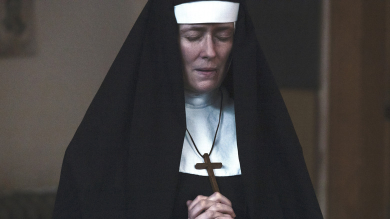 Sister Mary holding a cross and praying in "1923"