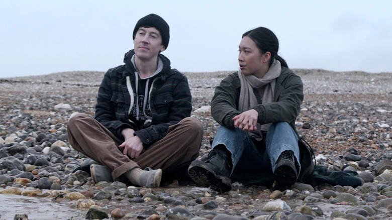 Will Downing and Jin Cheng sitting on a rock beach in 