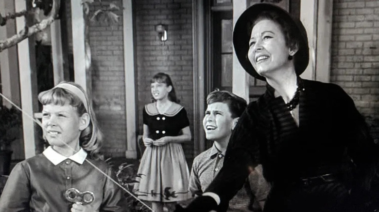 Grandma flies a kite while dressed in a black dress and hat as kids Anne, Karen and Tom look up at the sky on The Twilight Zone (1959-1964)