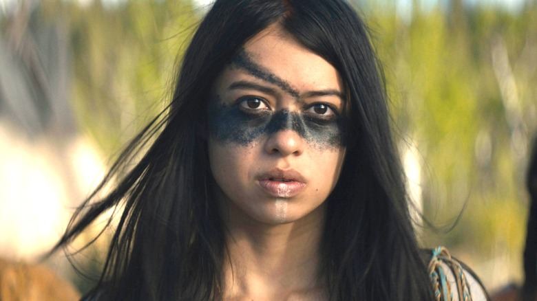 Naru with black and white paint across her face in "Prey."