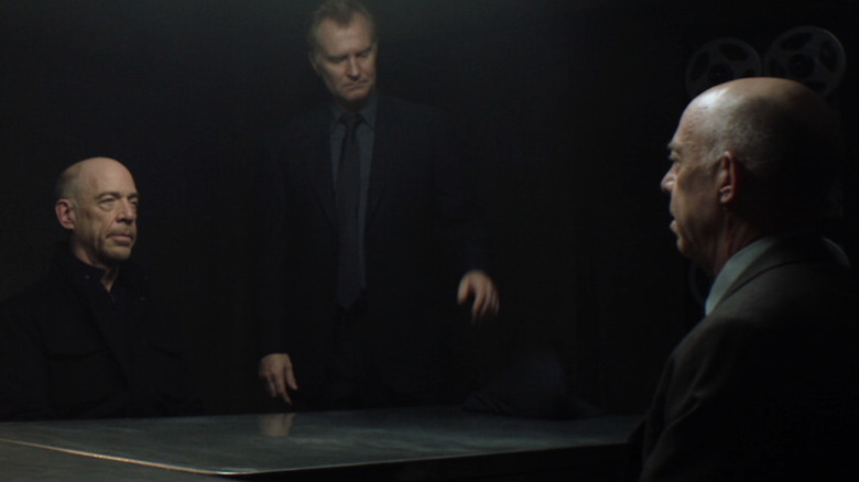 Howard Silk sits across an interrogation table facing his double, Howard Silk, while Josef Aldrich oversees the interrogation in "Counterpart"