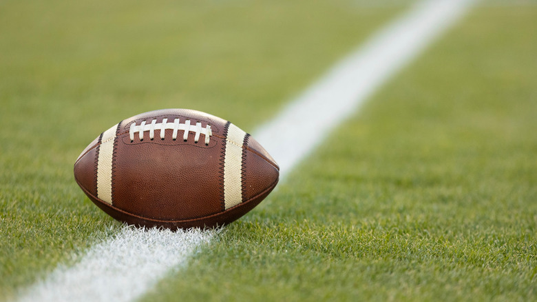 Close-up of a football resting on a white line on a football field
