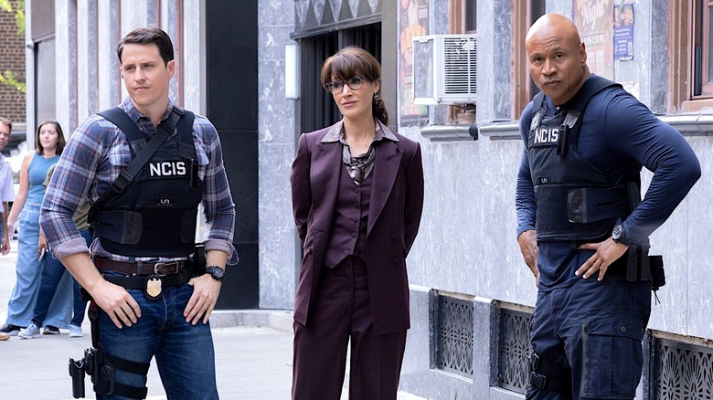 Wyatt Hill, Robyn Wells, and Sam Hanna standing next to each other on a New York street in NCIS: New York