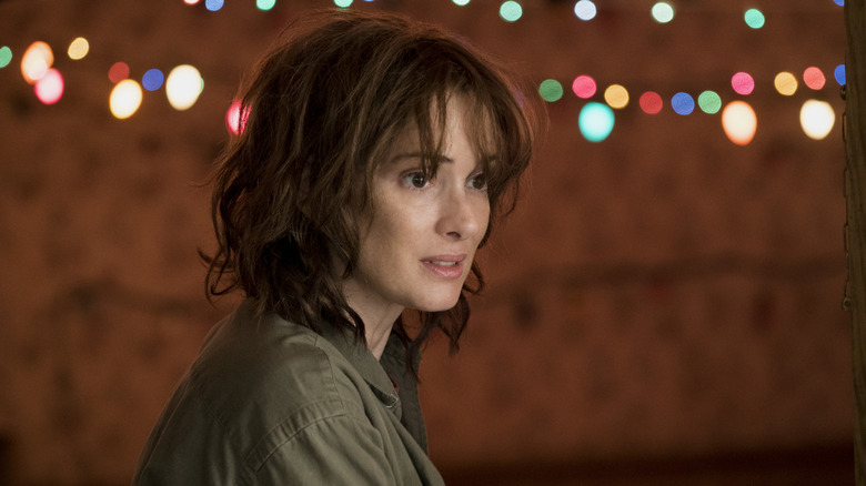 Winona Ryder as Joyce stood in front of Christmas lights