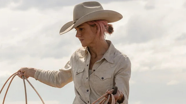 Jennifer Landon's Teeter wearing white and handling a lasso on Yellowstone
