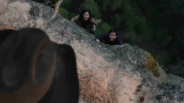 Rip (Cole Hauser) observing tourists dangling from a cliff on "Yellowstone."